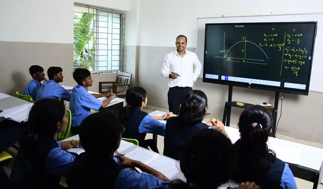 Vedanta students learning with a teacher at an interactive classroom board